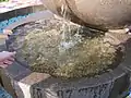 Bowl with coins left by visitors. Fountain "Apple" on top of the Kok-Tobe.