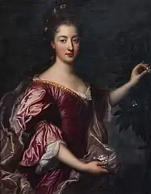 Young woman in a red dress, with long curly hair.