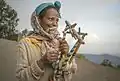 Egyptian woman holding a pair of Egyptian simsimiyya lyres. According to the New Grove Dictionary of Musical Instruments, Egyptian simsimiyyas had 5 strings. Others had six strings. Images of modern instruments may have as many as 12 strings.