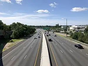 a wide road with many shops on both sides on a sunny day in Paramus