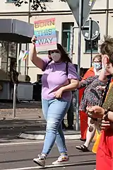 A woman holding a "Born This Way" sign