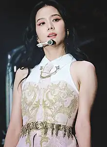 Jisoo looking towards the camera in a black coat
