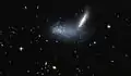 Irregular dwarf galaxy PGC 16389 covers its neighboring galaxy APMBGC 252+125-117.