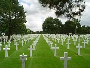 A photogprah of white grave markers on green grass at the Normandy American Cemetery and Memorial near Omaha Beach in France