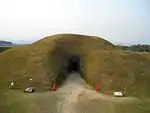 Grass covered hillock with an entrance.