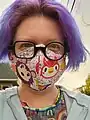 Decorative face masks to prevent the spread of COVID-19 was common in the early 2020s; vaccination status of individuals also became culturally relevant during the decade. Pictured here is a mask based off the game Animal Crossing: New Horizons, a popular video game during the pandemic.