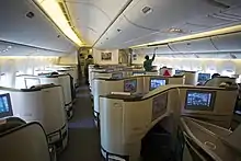 Airline business cabin. Rows of seats arranged between aisles.
