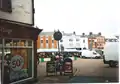 The building on extreme left foreground (the one where the sign is cut off to read " 'hop".) apparently has, on its Market Place-facing side, musket ball holes which date from the English Civil War. It was built in 1570. The muskets were fired from the castle, which stood on the other side of the Market Place, roughly where that row of buildings in the background stands.