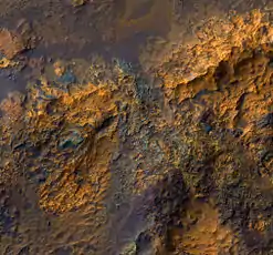 Bedrock in Luki Crater, enhanced HiRISE color image. The central region of the crater consists of uplifted ancient bedrock with a variety of rock types, indicated by the range of colors. Image is about 1&nbsp;km. wide.