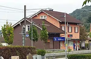 Two story salmon-colored building with adjoining freight house