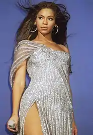 A woman stands with a microphone
