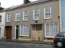 Photograph of a modest two-story house.