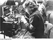 Danish detainee wears a D armband during assignment to forced labor in factory outside the camp.