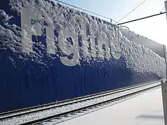 Station sign covered by ice