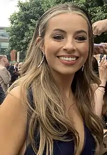 Woman with light brown hair smiling.