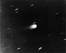 Gray scale photograph of Kohoutek, appearing as a bright, teardrop-shaped object at center with a faint tail