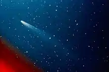 A color image of Comet Kohoutek, with its tail pointed towards the bottom right with the coma at top left