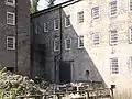 The 1771 mill showing the end of the aqueduct on the left and the hole in the wall where the wheel was located