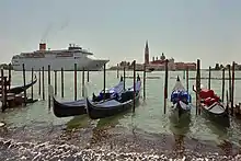 Cruise ship in the background passing several gondolas