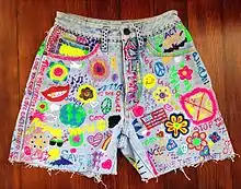 Image 115Acid washed jean shorts with grunge and hippie inspired DIY slogans and pictures. (from 1990s in fashion)