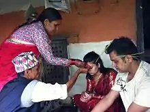 Puting tika on forehead and jamara above ears