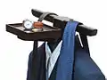 A suit with accessories on a valet stand.