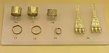 Image 29Finds from an early geometric Cremation Burial of a pregnant wealthy woman, from the N.W. of the Areopagus, about 850 BC, Ancient Agora Museum (Athens); exhibit 14–16: broad gold finger rings; exhibit 17–19: gold finger rings; 20: pair of gold earrings with trapezoid endings (from Greek Dark Ages)