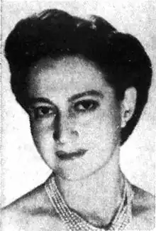 Black and white photograph of a woman in evening attire with short hair and a wide necklace with five rows of gems