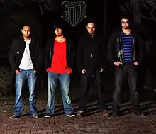 Four men standing in a row and posing for photo
