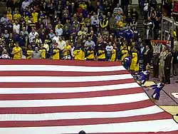 Michigan basketball team in gold (maize) uniforms during the national anthem