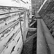 Carpenters' bracket scaffolding or wall brackets bolt through, and hang from, a wall.