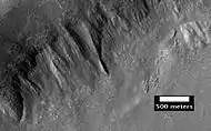 Place where a lobate debris apron begins.  Note stripes which indicate movement.  Image located in Ismenius Lacus quadrangle.