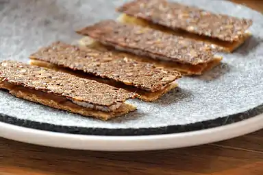 Rye bread and chicken skin with rygeost (Danish smoked cheese) and wolffish roe.