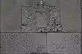 Stone-of-arms bearing an inscription.