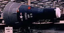 A spacecraft in a museum, displaying a United States Air Force color scheme