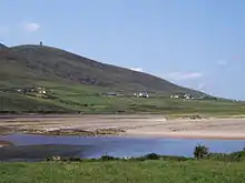 A village at the foot of a mountain, seen across a bay