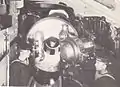 The starboard 12-inch (305&nbsp;mm) Mark VIII gun in one of the turrets aboard the battleship HMS Illustrious. The gun's breech is open.