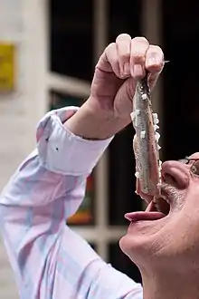 Eating "Hollandse Nieuwe" (Dutch brined herring) the Dutch way.