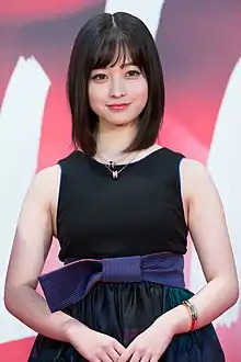 Kanna Hashimoto in sleeveless dress facing camera with arms lowered and hands folded in front of body