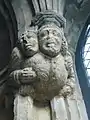 Decoration at the top of a pillar showing man carrying a disabled companion