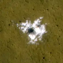 Water ice excavated by an impact crater that formed between January and September 2008. The ice was identified spectroscopically using CRISM.