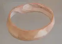 Indus bracelet made of Fasciolaria Trapezium or Turbinella pyrum imported to Susa in 2600–1700 BC. Found in the tell of the Susa acropolis. Louvre Museum, reference Sb 14473. This type of bracelet was manufactured in Mohenjo-daro, Lothal and Balakot. It is engraved with a chevron design which is characteristic of all shell bangles of the Indus Valley, visible here.