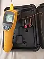 An industrial IR thermometer with integrated temperature probe