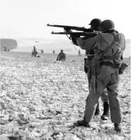 Infantrymen fire at German troops in the advance to relieve the surrounded paratroopers in Bastogne