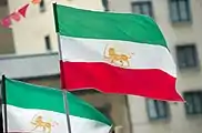 Two flags of the People's Mujahedin Lion and Sun flying.