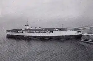 Aircraft carrier on the sea with cloudy sky in the background