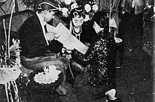 Kacar-kucur ceremony, groom pouring rice and coins into bride's scarf, c. 1960