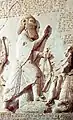 A close up photograph of the Behistun inscription showing the figure of Darius the Great. Note the detail in the arrow, and the positioning of the king and his hand posture