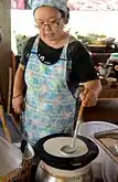 The batter for khao phan, as the noodle roll is called in Thailand, is spread out over a cloth stretched over a pot of boiling water.