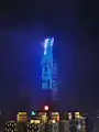 The KK100 building at night, with the top visible through low clouds.